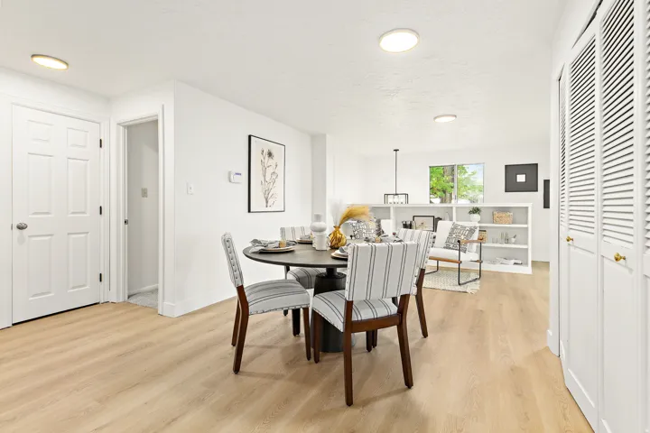 Open-concept living area featuring light wood-finish flooring, white walls, and recessed lighting