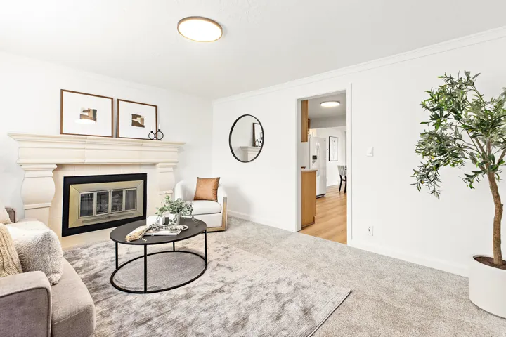 Living area featuring a stone mantel fireplace with an ornate firebox, crown molding, and ceiling-mounted lighting