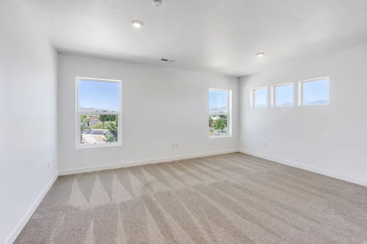 Spacious room featuring neutral carpeting and white walls