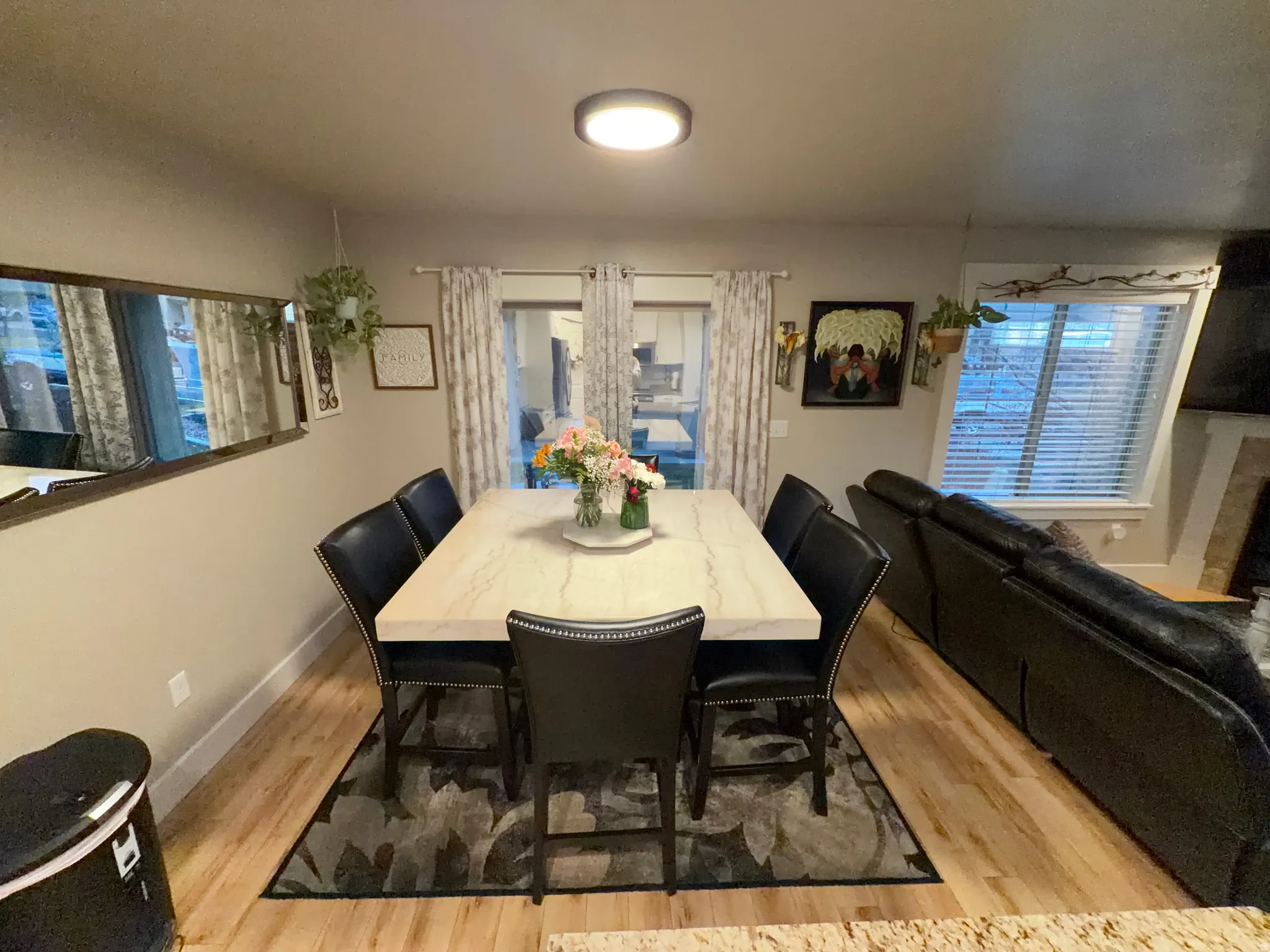 Dining area featuring wood-finish flooring and a contemporary overhead light fixture