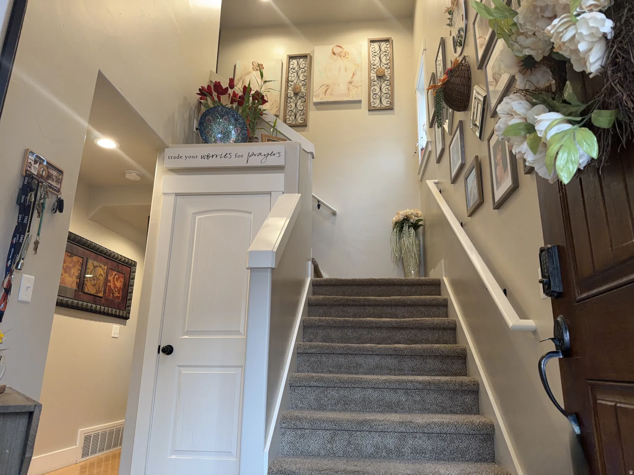 Carpeted staircase with white handrail and trim