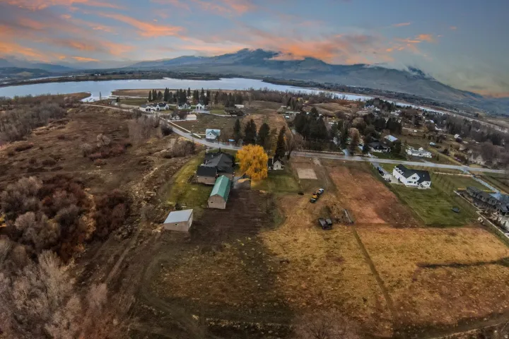 Expansive property featuring multiple structures, open fields, and proximity to a large body of water