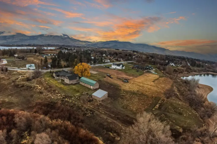 Expansive acreage featuring multiple structures, including a primary residence, a large green barn, and a smaller outbuilding