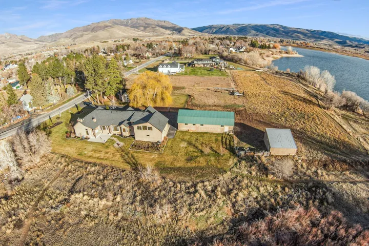 Expansive property featuring a single-story residence, a large green-roofed outbuilding, and an additional smaller outbuilding