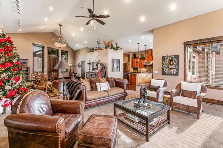 Spacious living area featuring vaulted ceilings, recessed lighting, and a ceiling fan