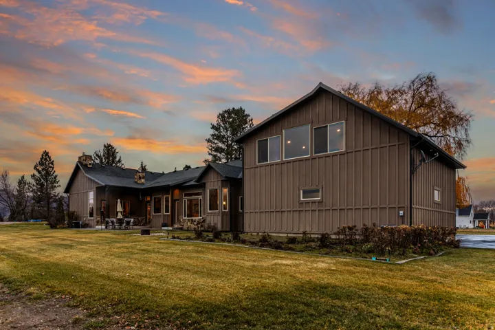 Expansive property featuring a brown board and batten exterior and a dark shingle roof