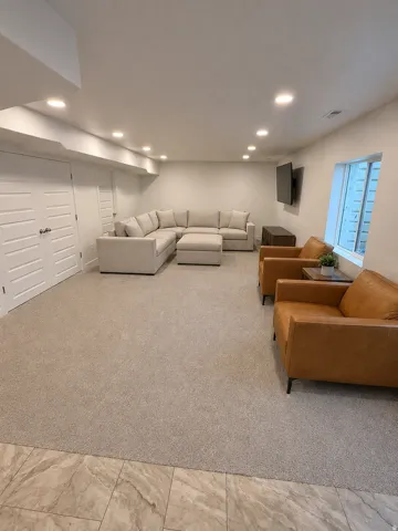 Spacious lower level room featuring recessed lighting, light-toned carpeting, and a window well