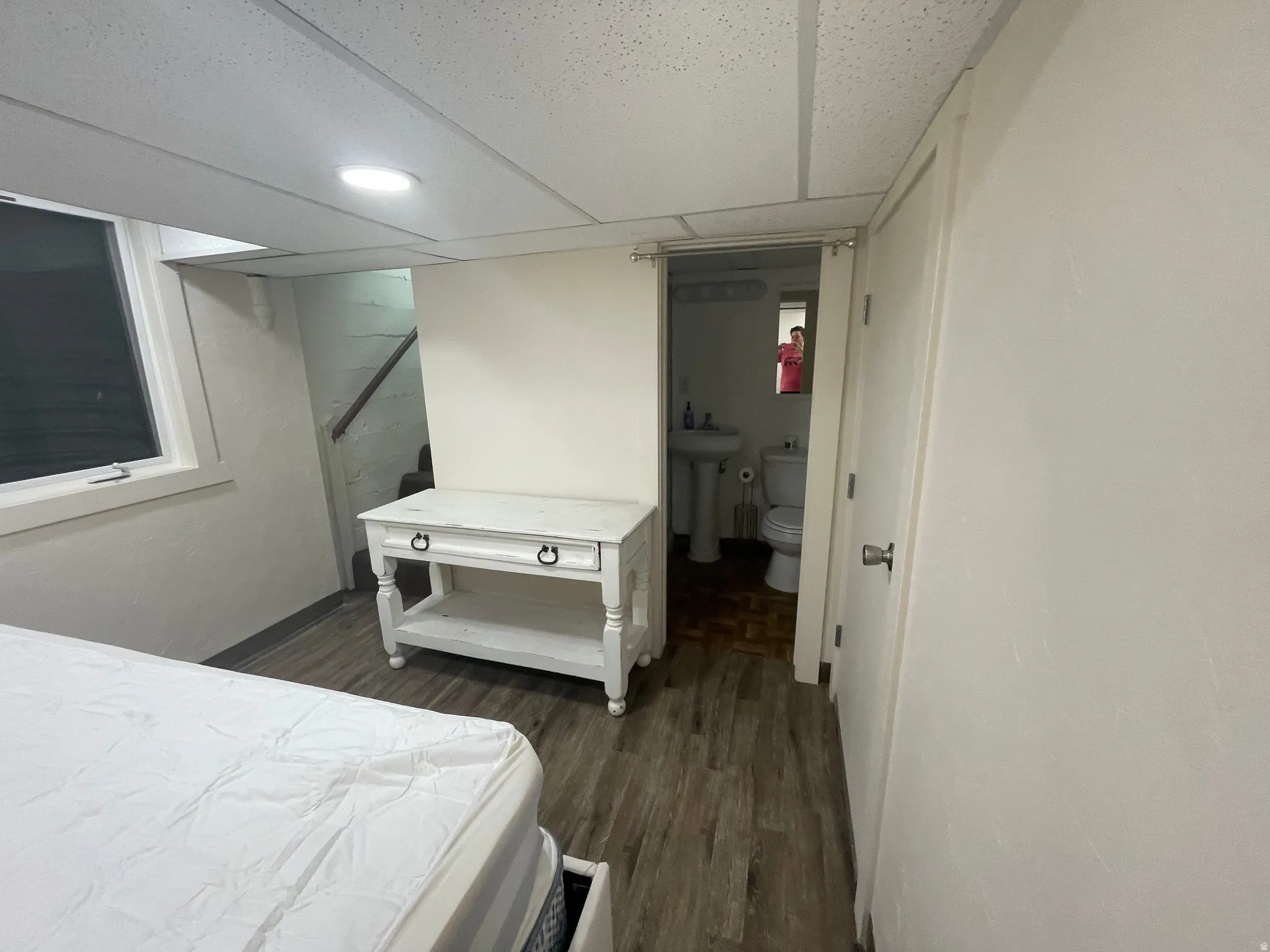 Room featuring wood-finish flooring, recessed lighting, and a window with white trim