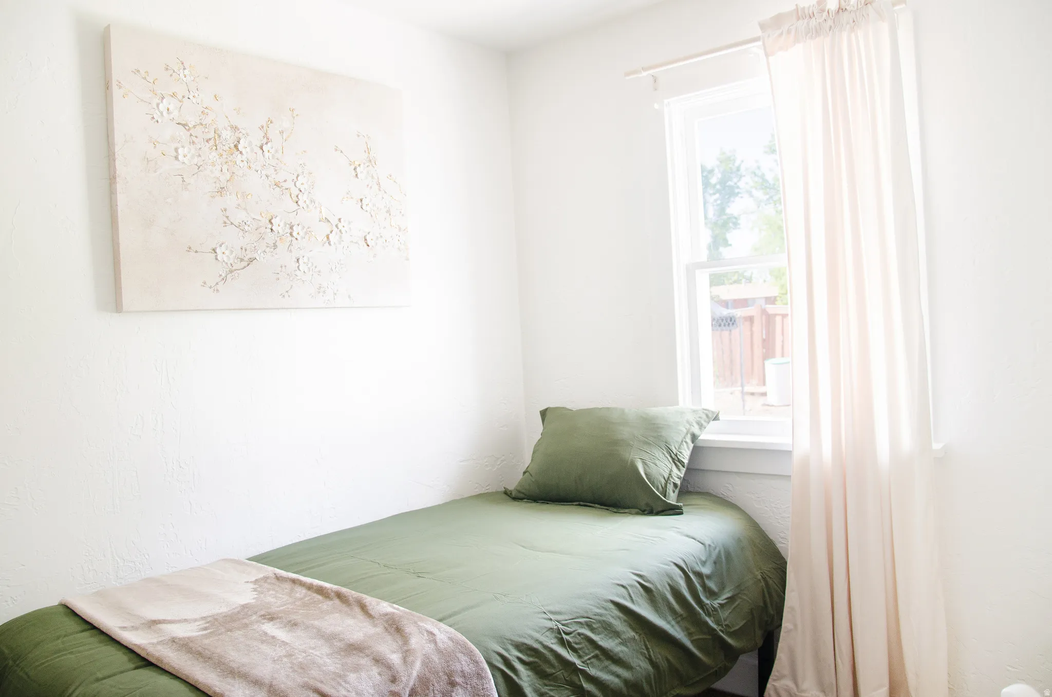 Bright interior space featuring a window with natural light, white wall finishes, and a single-pane window