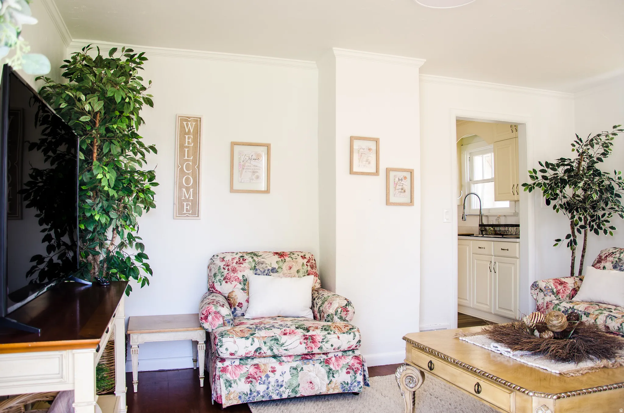 Living area featuring crown molding and dark wood-finish flooring