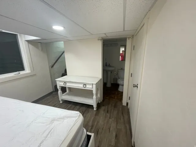 Room featuring wood-finish flooring, recessed lighting, and a window with white trim