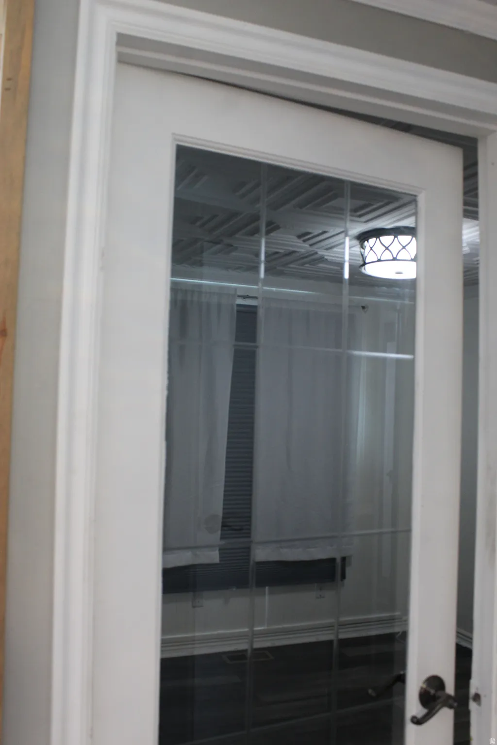 First bedroom. White French door with glass panels and a dark-finish door handle. First bedroom door