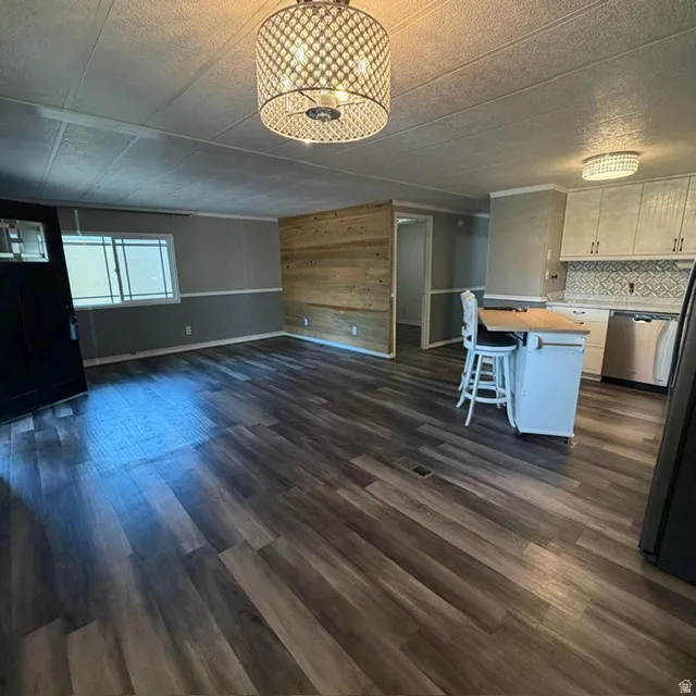View from the Dining Area. Open-concept living area featuring wood-finish flooring, a decorative accent wall, and a crystal-beaded ceiling light fixture