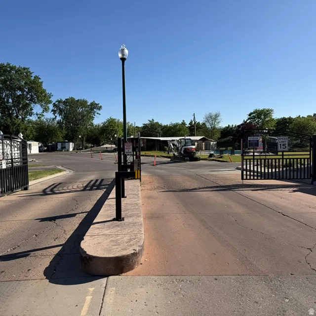 Gated entry with black wrought iron fencing and a central lamppost