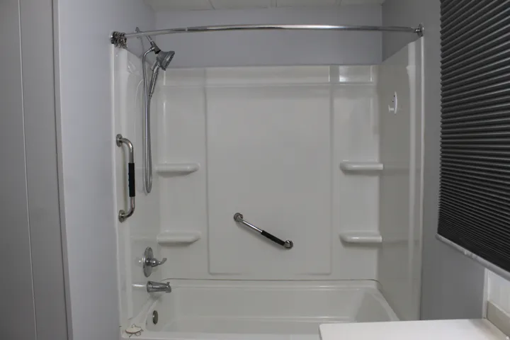 Primary bathroom White acrylic tub and shower combination with chrome fixtures
