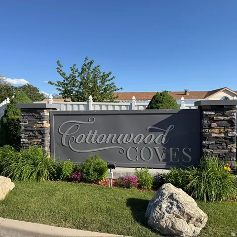 Cottonwood Coves entry monument with stacked stone pillars and a dark grey sign panel