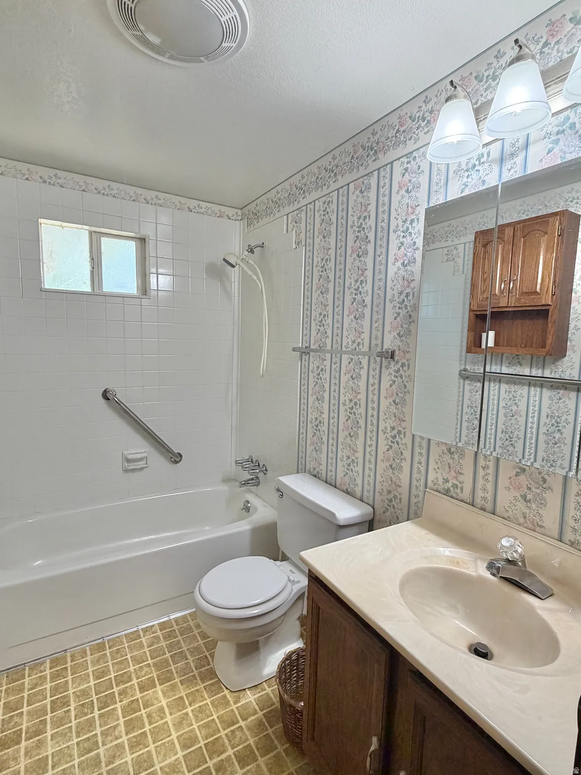 Bathroom featuring a vanity with a light-toned countertop, integrated sink, and wood-finish cabinetry