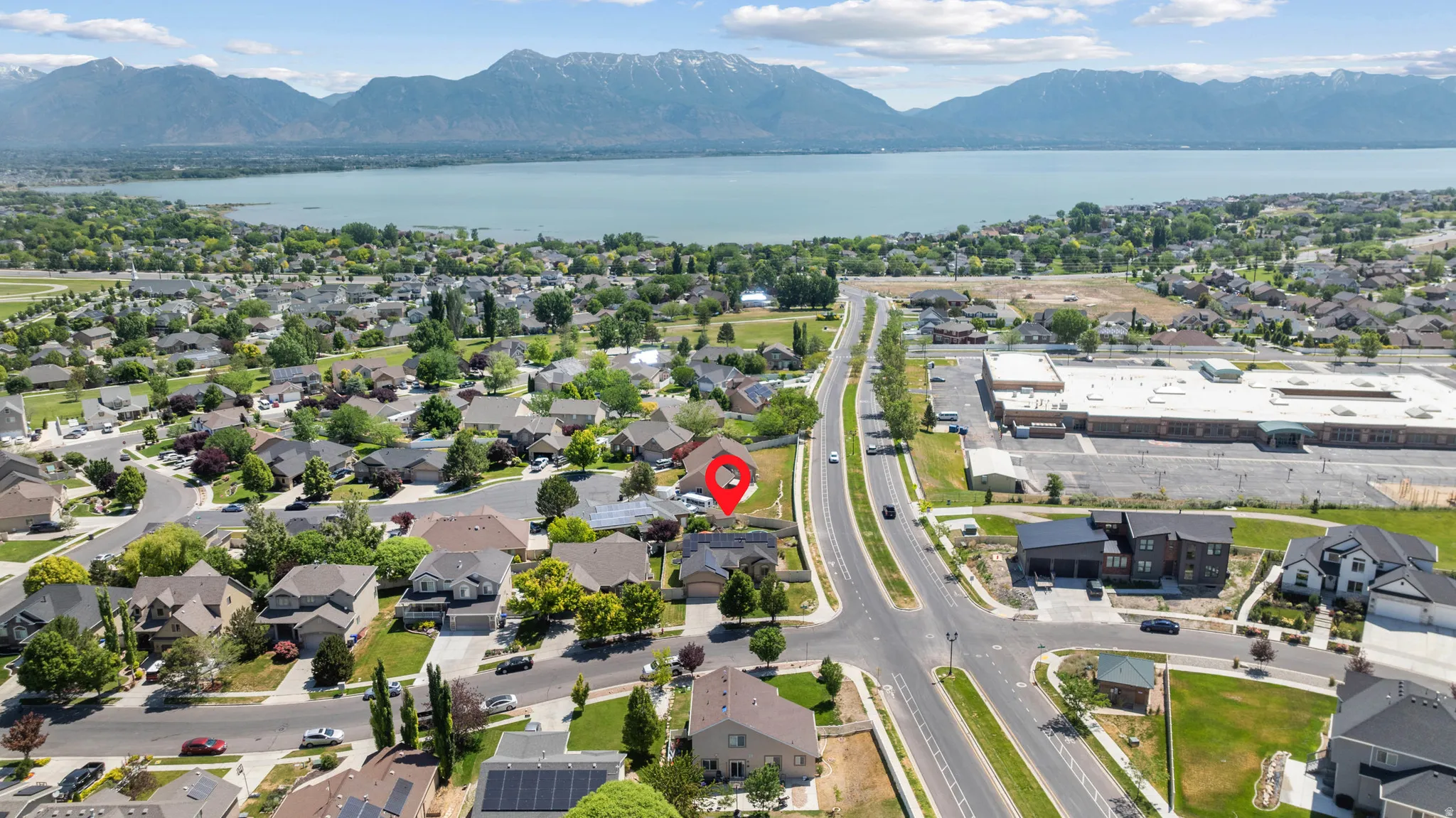 Aerial perspective showcasing residential neighborhood with lake and mountain views.
