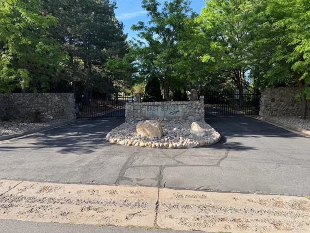 East Bench at 29th Gate Entry - Stone entry monument featuring "East Bench" inscription, flanked by stone walls and a wrought iron gate