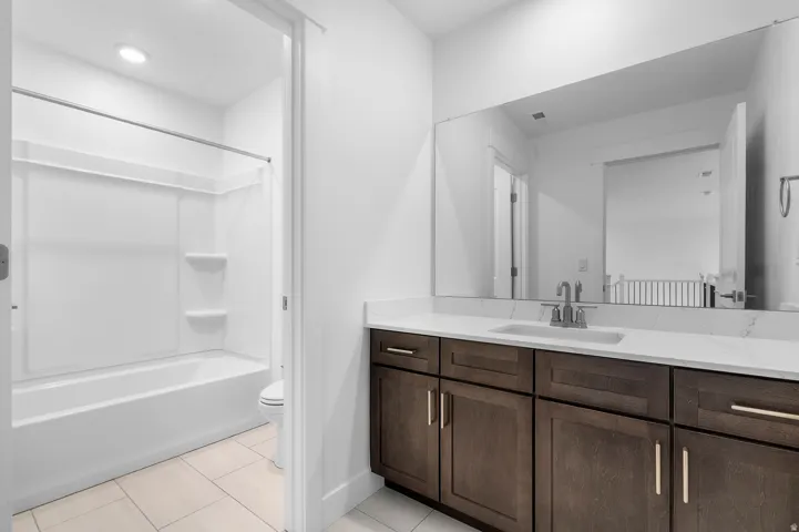 Bathroom vanity featuring a quartz-finish countertop and undermount sink