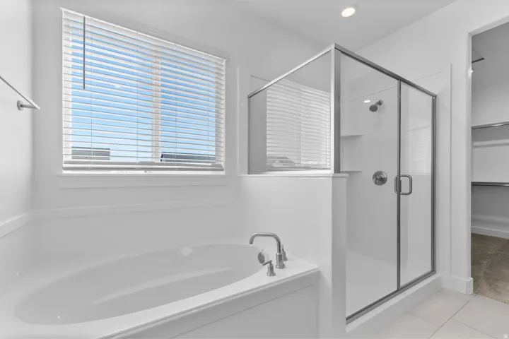 Contemporary bathroom featuring a built-in soaking tub with deck-mounted faucet, a separate glass-enclosed shower, and a window with horizontal blinds