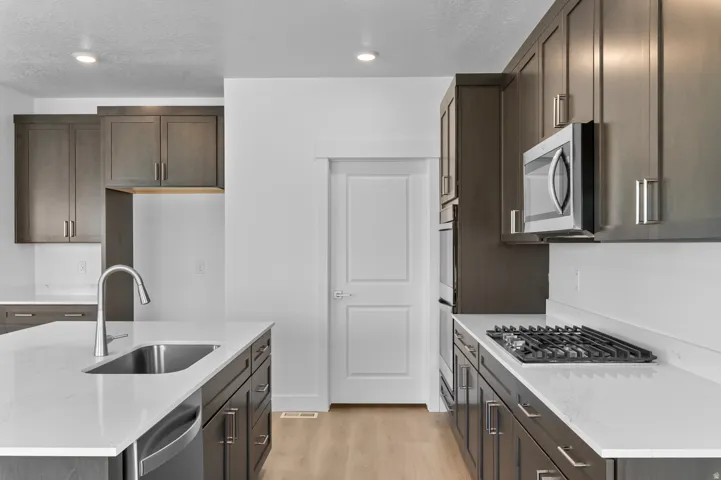 Modern kitchen featuring dark wood cabinetry and light countertops