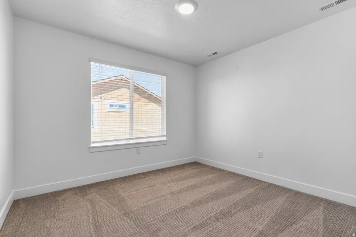 Bright room with neutral wall paint and plush carpet flooring