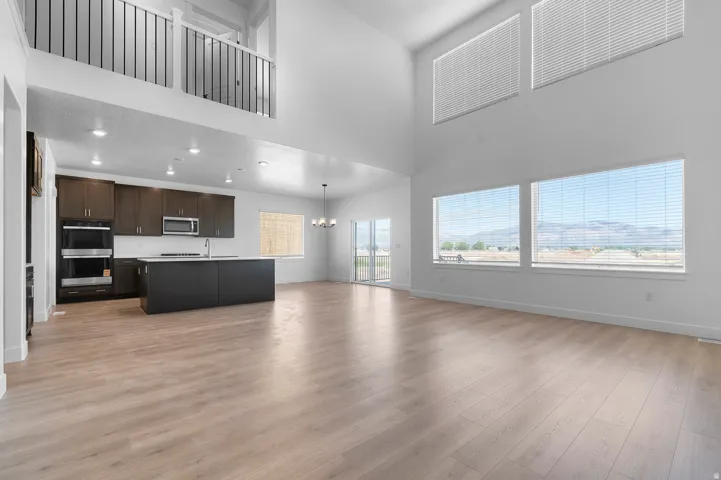 Open-concept living space featuring high ceilings and wood-finish flooring