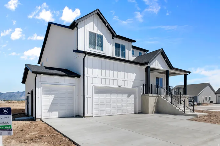 Modern farmhouse exterior featuring white board and batten siding, black trim, and a prominent front porch with dark pillars