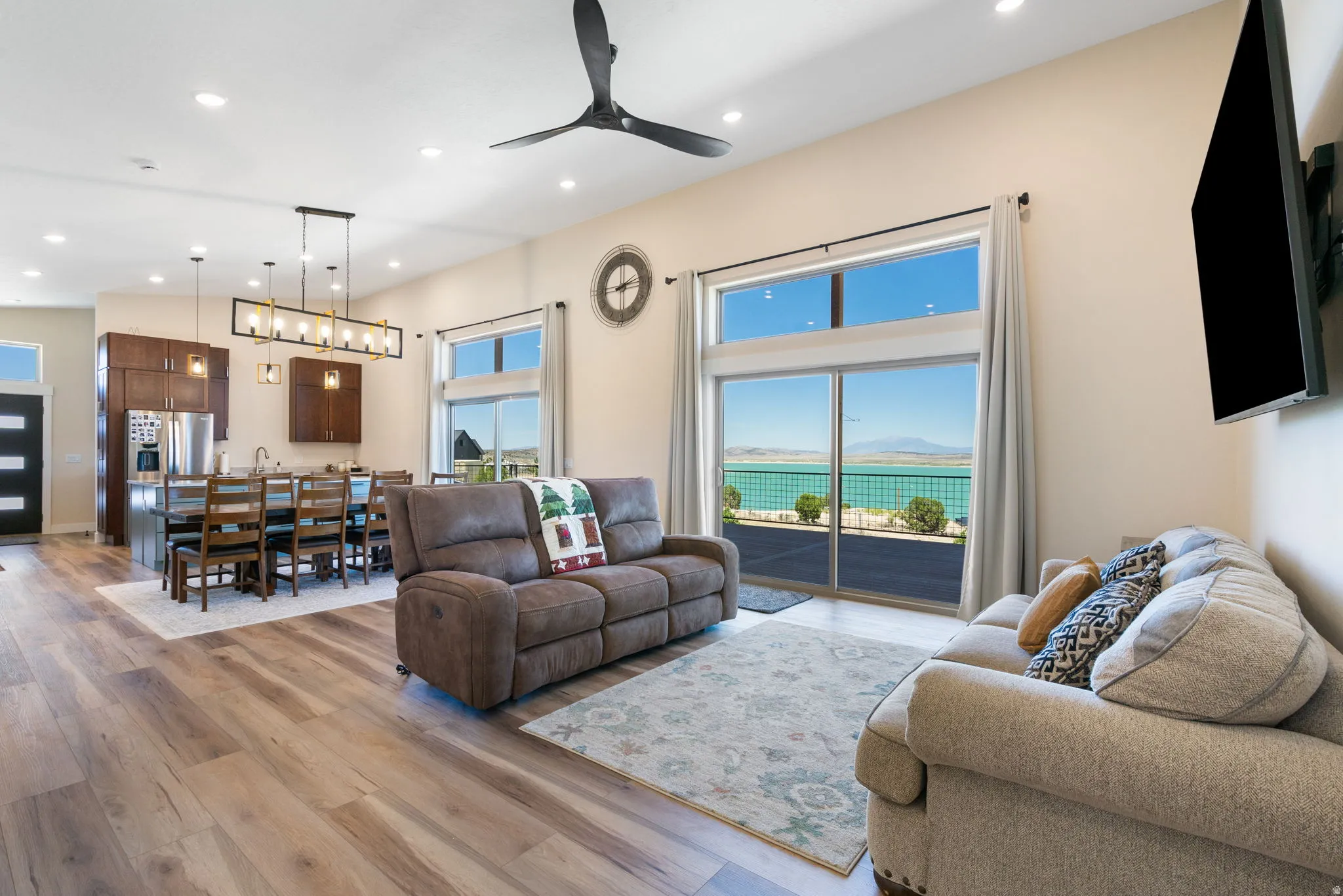 Open-concept living space with expansive sliding glass doors, wood-finish flooring, and recessed lighting