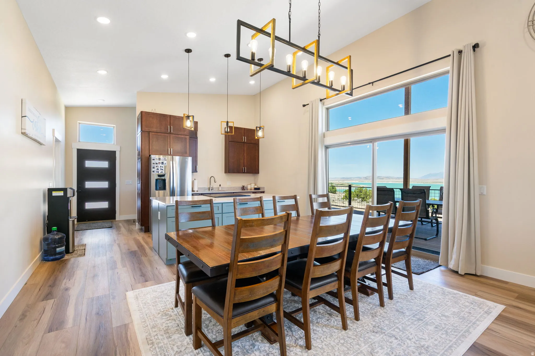 Open-concept living area featuring high ceilings, wood-finish flooring, and a contemporary dining space