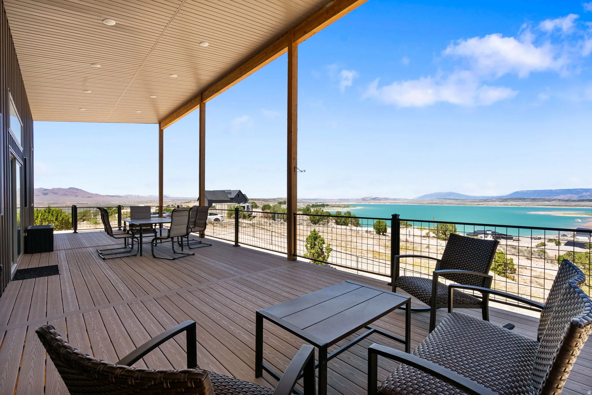 Expansive covered deck featuring composite decking and a black metal railing system
