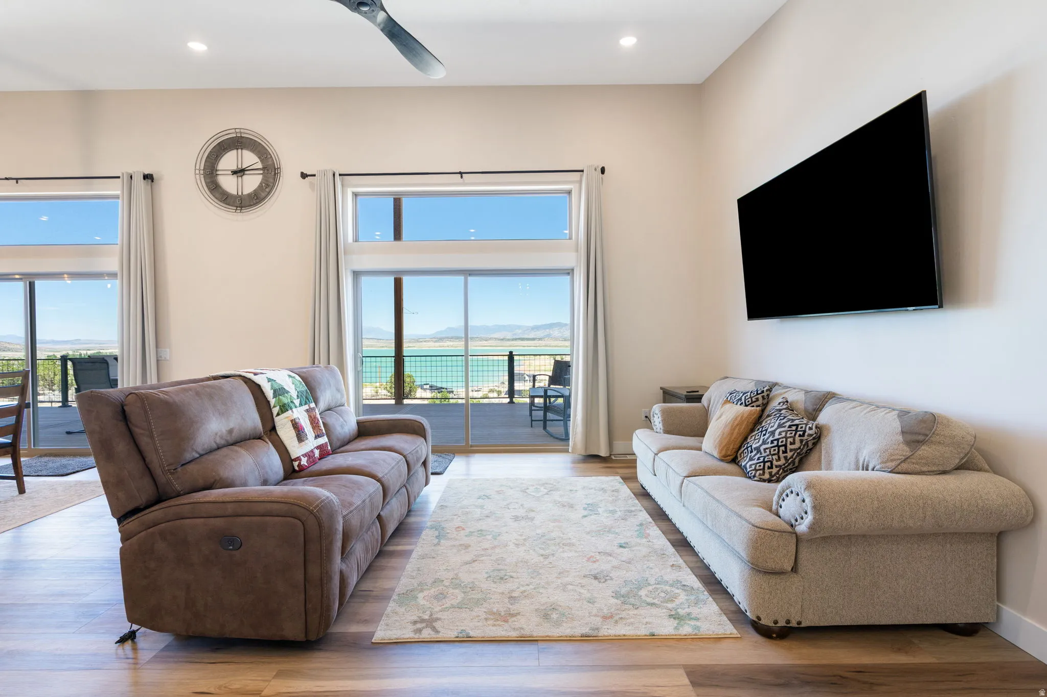 Living area featuring high ceilings, light-toned walls, and wood-finish flooring