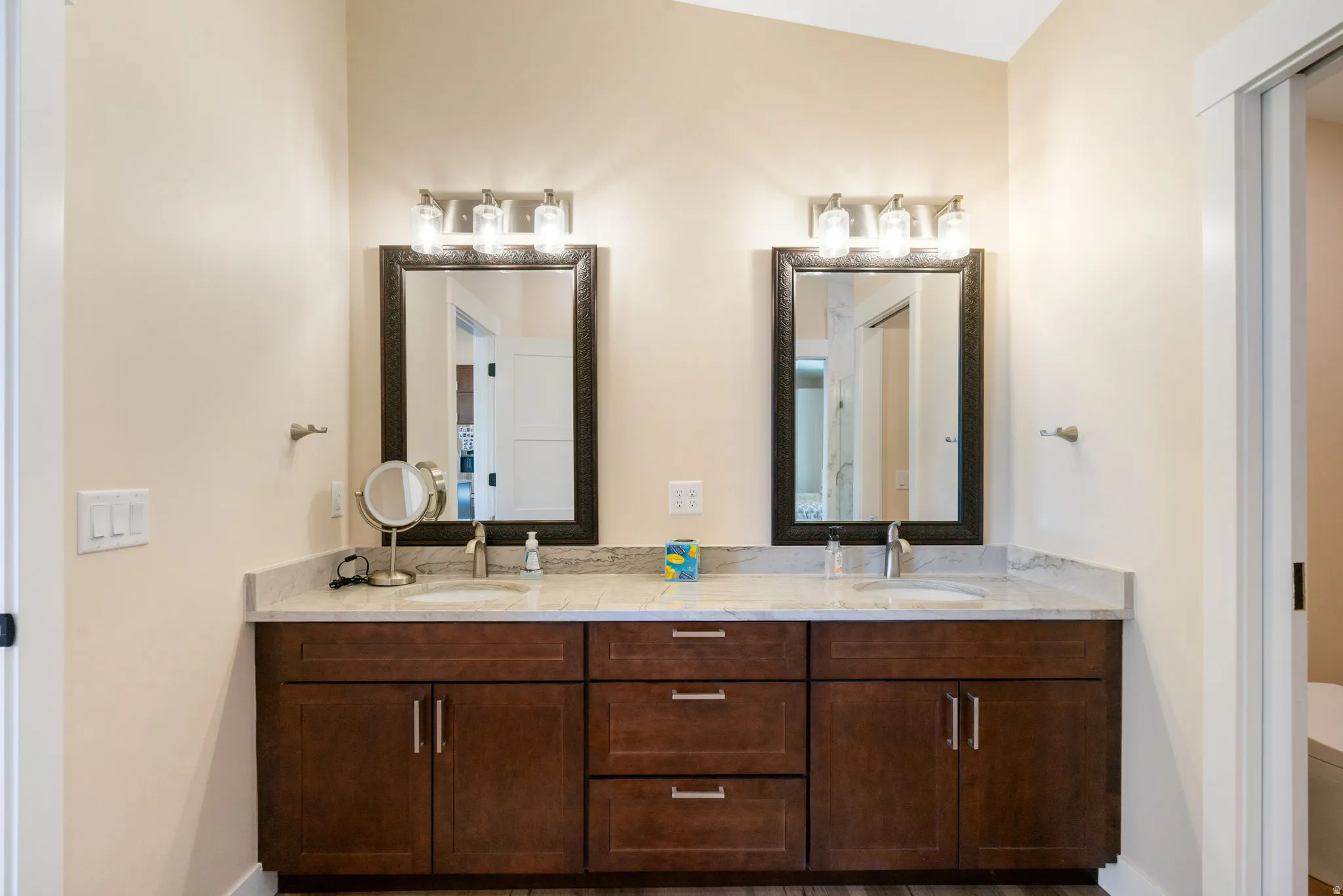 Dual vanity featuring dark wood cabinetry, light-toned countertop, and undermount sinks