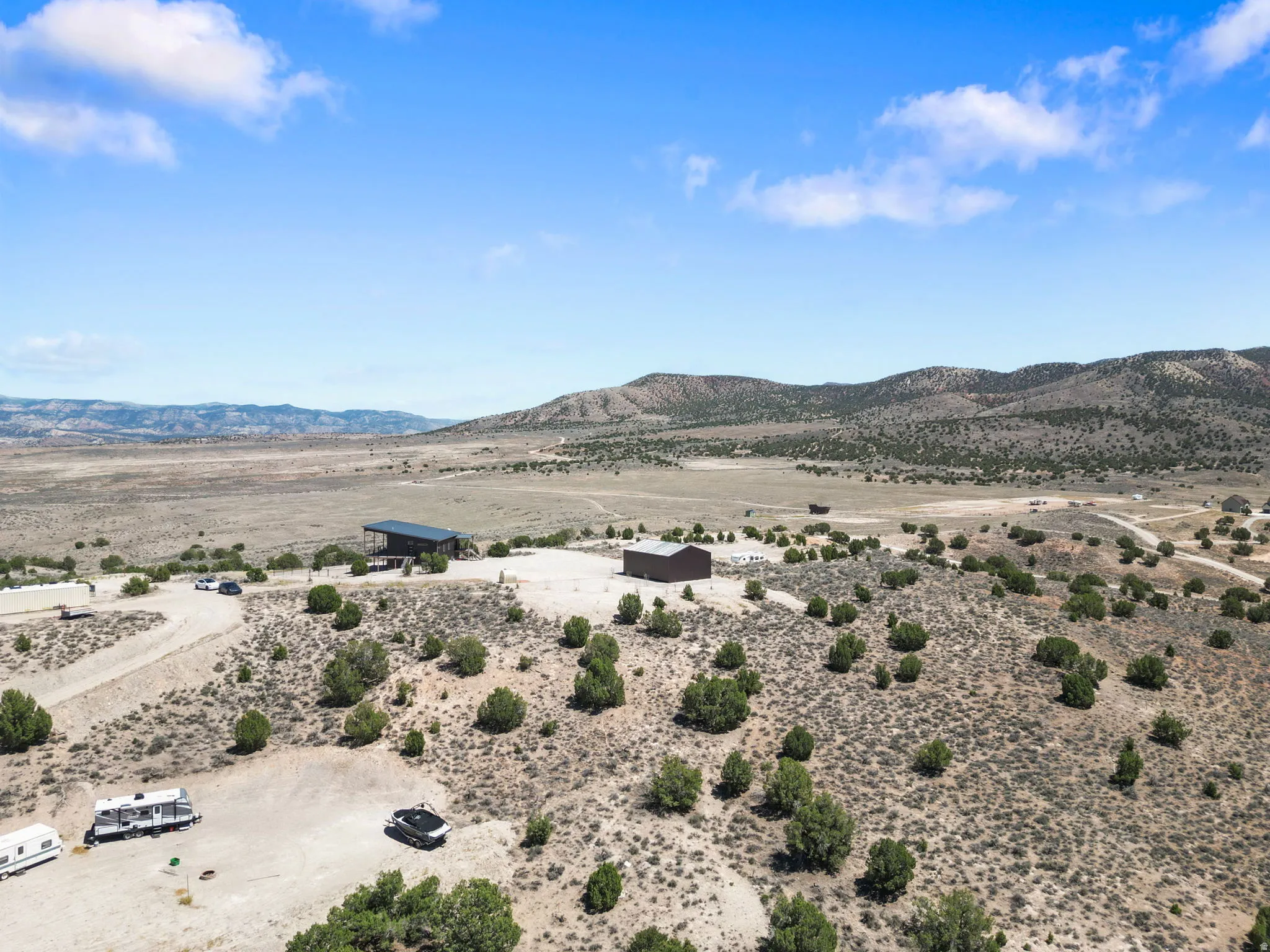 Expansive arid landscape featuring scattered green shrubs and distant mountains