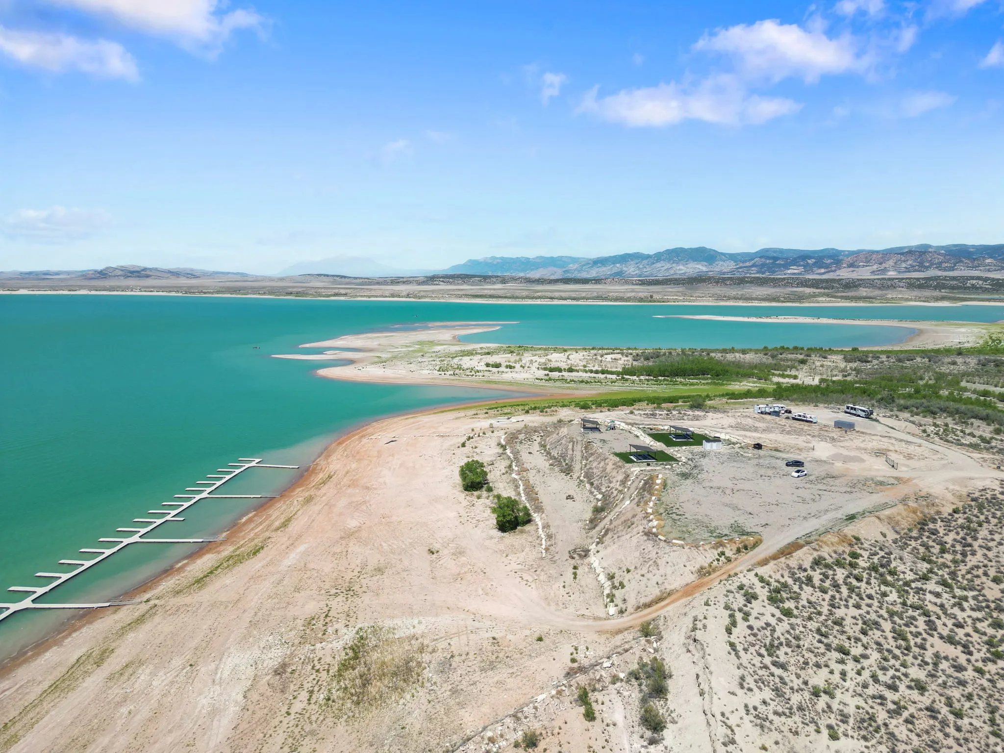 Expansive waterfront property featuring a long dock system, direct access to the water, and distant mountain ranges