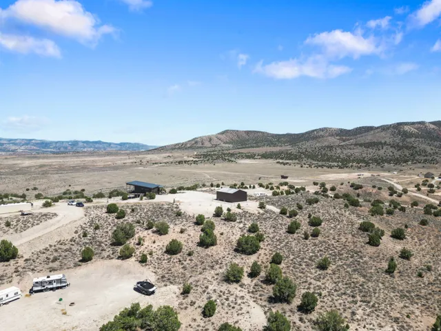 Expansive arid landscape featuring scattered green shrubs and distant mountains