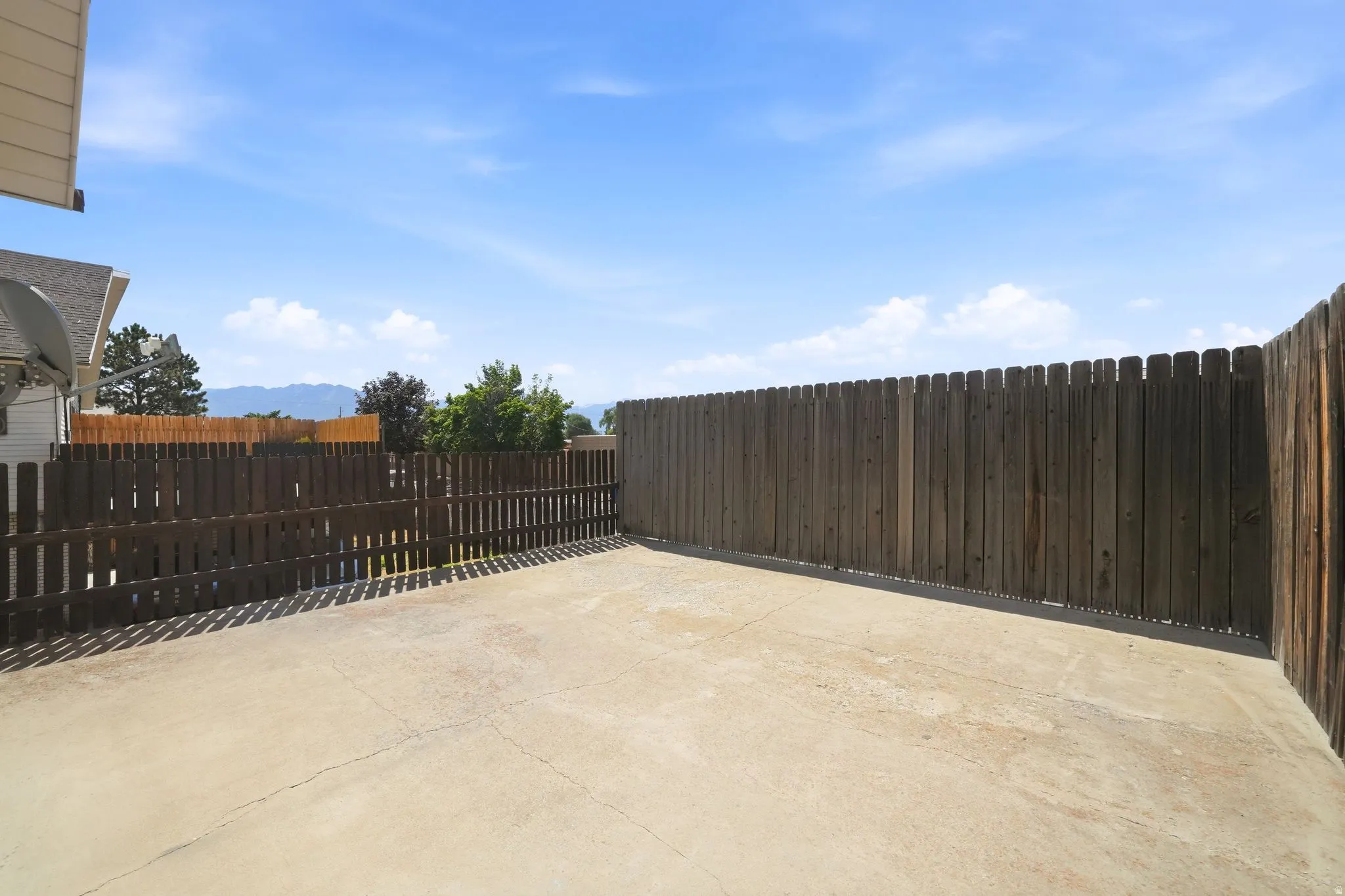 Concrete patio area featuring a perimeter wood fence