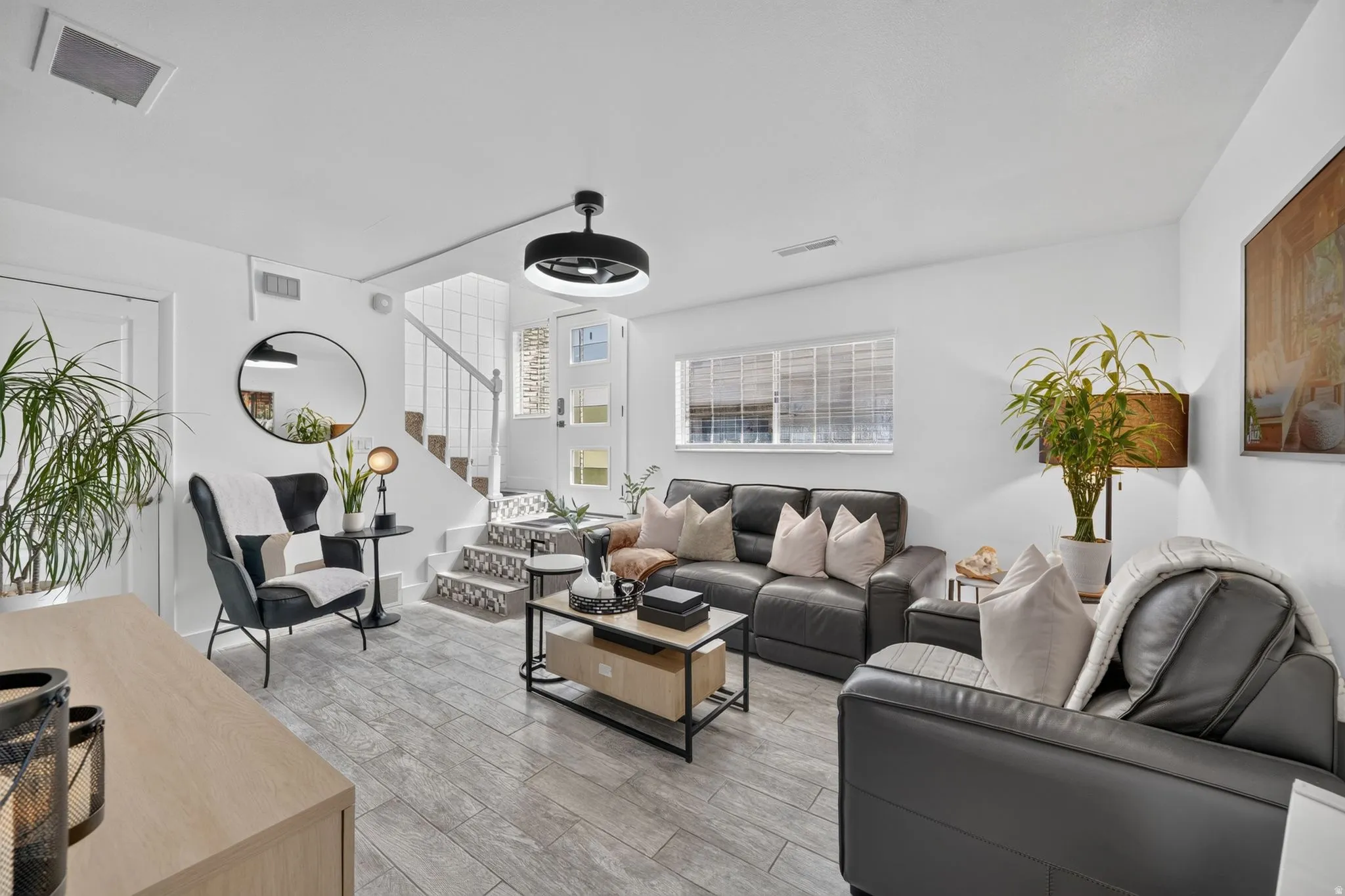Living area featuring wood-finish tile flooring and crisp white walls
