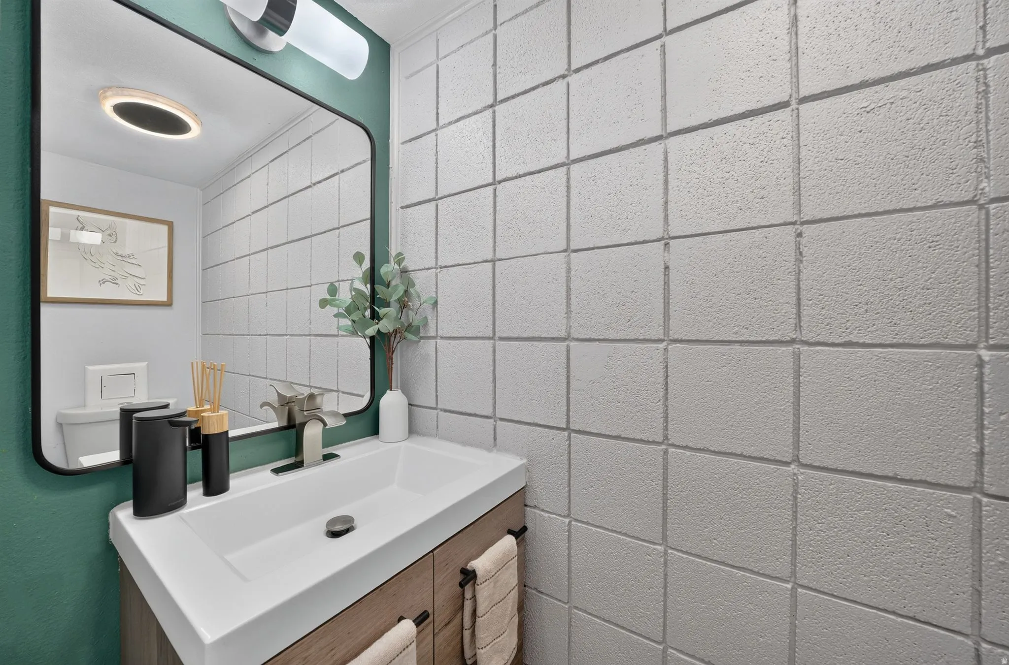 Contemporary bathroom featuring a floating wood-finish vanity with an integrated rectangular sink