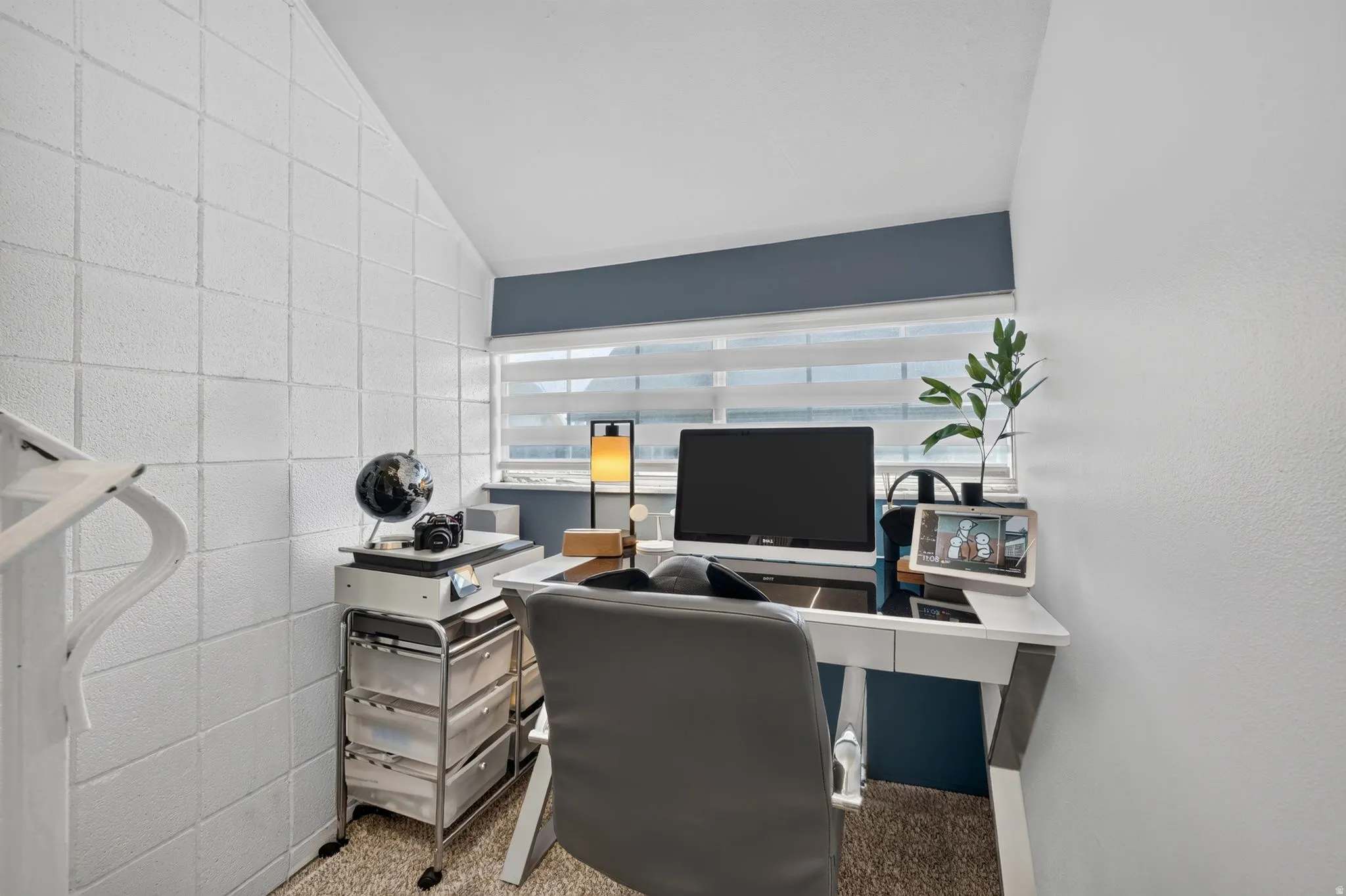Dedicated workspace featuring an angled ceiling and textured wall panels