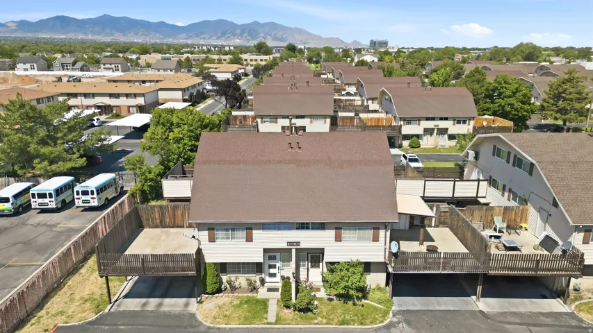 Multi-unit residential structure featuring a brown shingle roof and light-colored siding