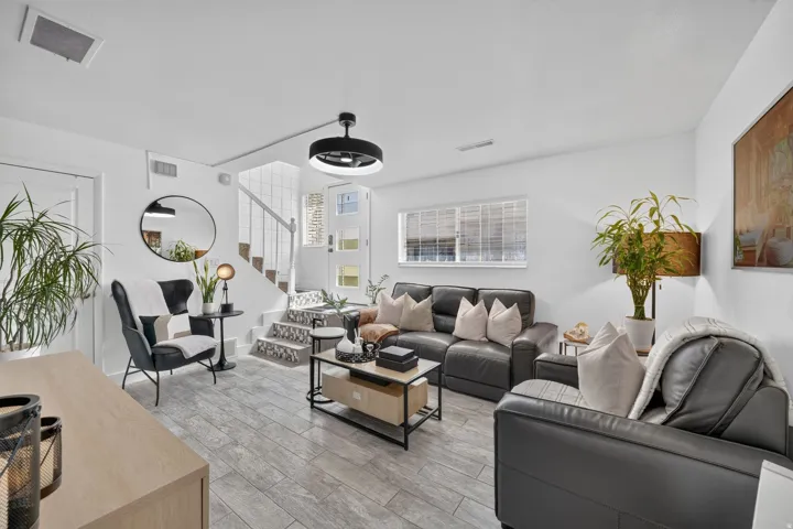 Living area featuring wood-finish tile flooring and crisp white walls