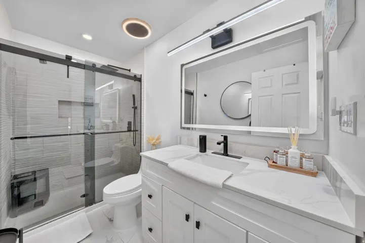 Bathroom featuring a modern vanity with a white countertop and integrated sink