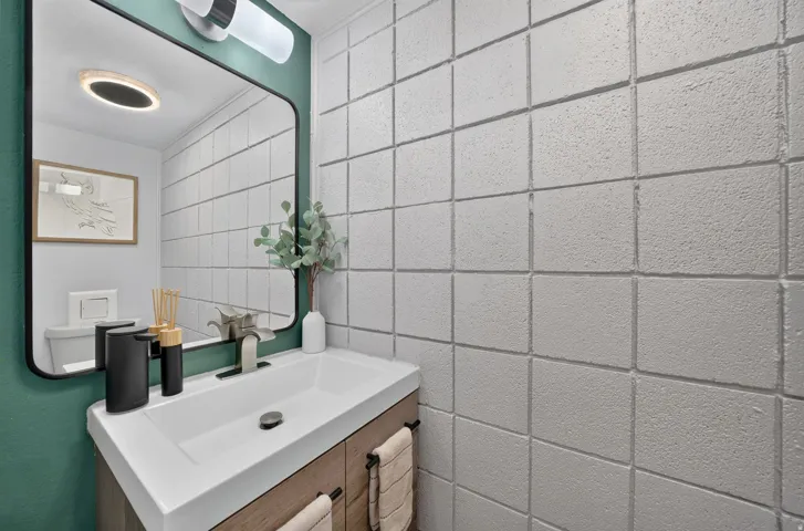 Contemporary bathroom featuring a floating wood-finish vanity with an integrated rectangular sink