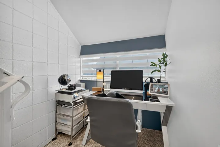 Dedicated workspace featuring an angled ceiling and textured wall panels