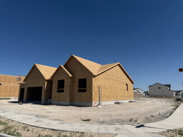 New construction home featuring a concrete foundation, unfinished exterior sheathing, and a multi-pitch roofline