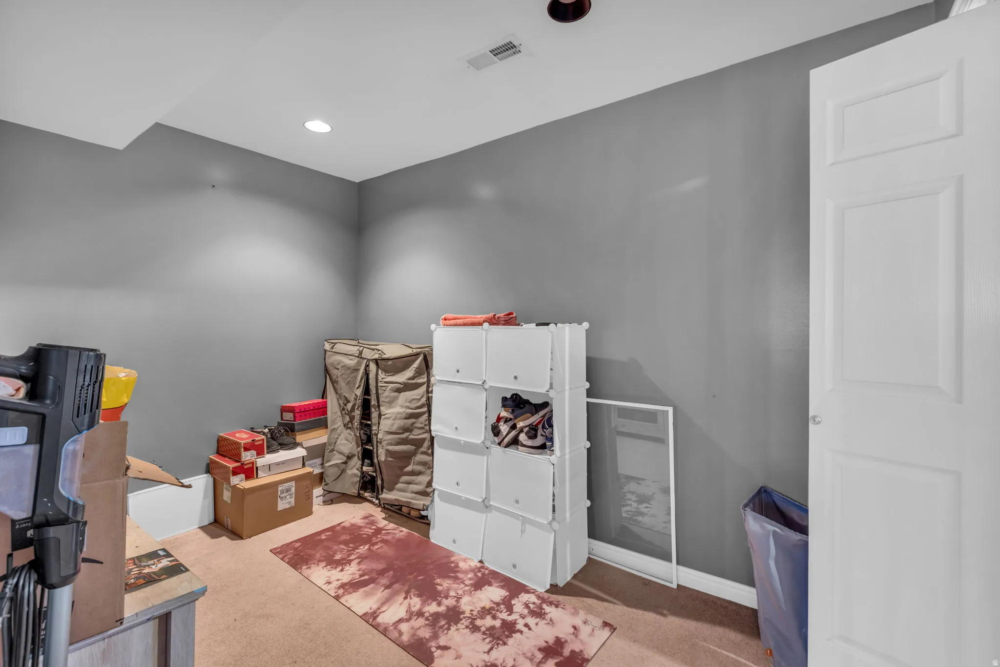 Room featuring gray painted walls, recessed lighting, white trim, and a white paneled door