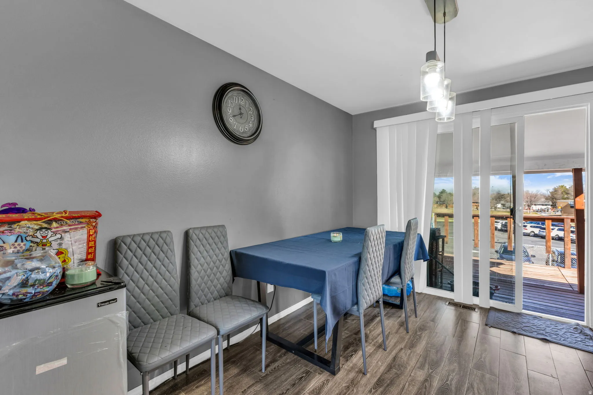 Dining area featuring wood-finish flooring, gray wall paint, and a modern pendant light fixture