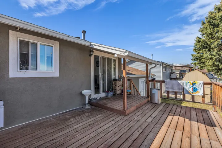 Expansive wooden deck featuring sturdy railings and a covered portion